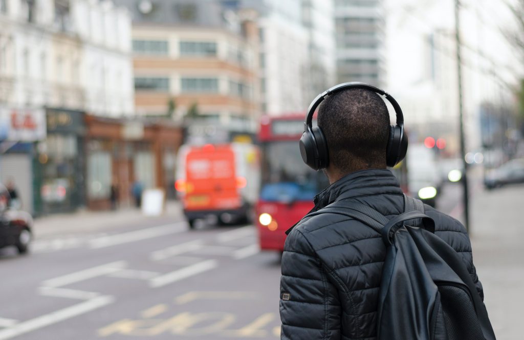 Man wearing headphones waiting for a bus